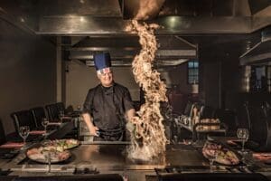 Teppanyaki chef with fire cooking