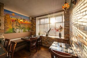 Efendy Turkish Restaurant Photos by Bevan Cockerill- Interior shot of dining tables with sun shining through window and a picture of Cappadocia Hot Air Balloons